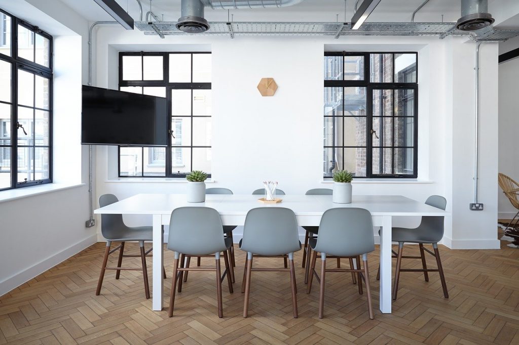 salle de réunion avec une grande table et un écran